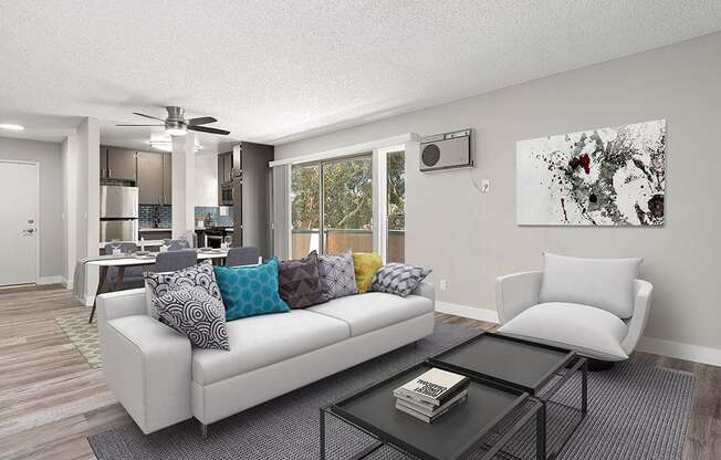 Hardwood floored living room with view of dining area, kitchen, and balcony.