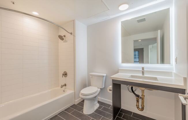 a bathroom with a toilet sink and tub and a mirror