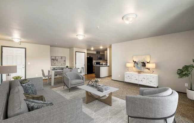 a living room with grey couches and chairs and a white coffee table in front of a  at Altitude, East Wenatchee