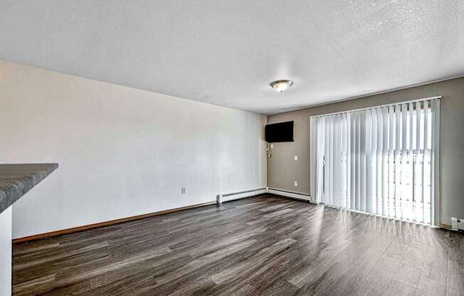 the living room and dining room of an apartment with wood flooring