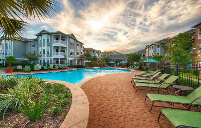 a swimming pool in front of an apartment building at Volare at the Woodlands, The Woodlands, TX, 77384