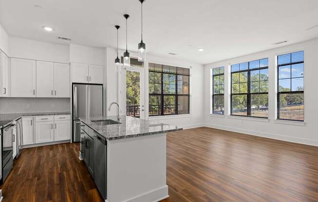 A modern kitchen with wooden floors and a large island.
