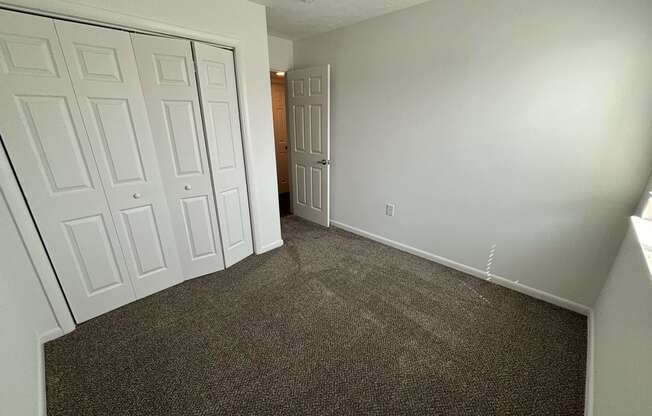 a bedroom with two closets and a carpeted floor