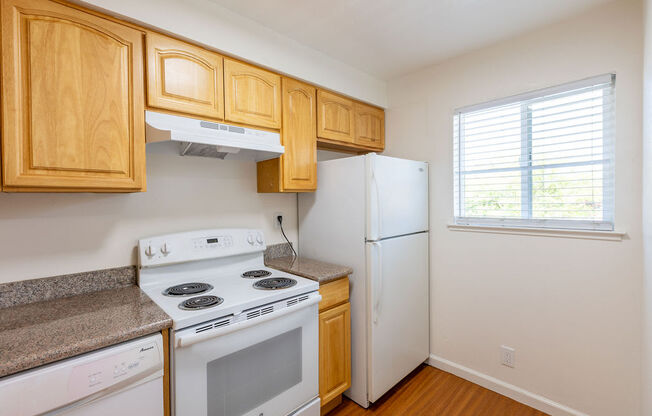 a kitchen with white appliances and wooden cabinets