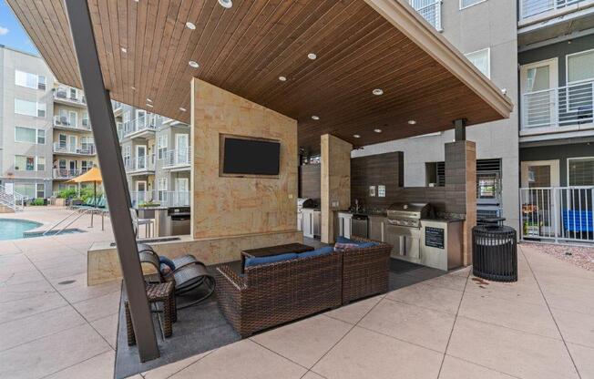 a covered patio with a kitchen and a pool