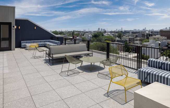 A balcony with a yellow chair and a white table.