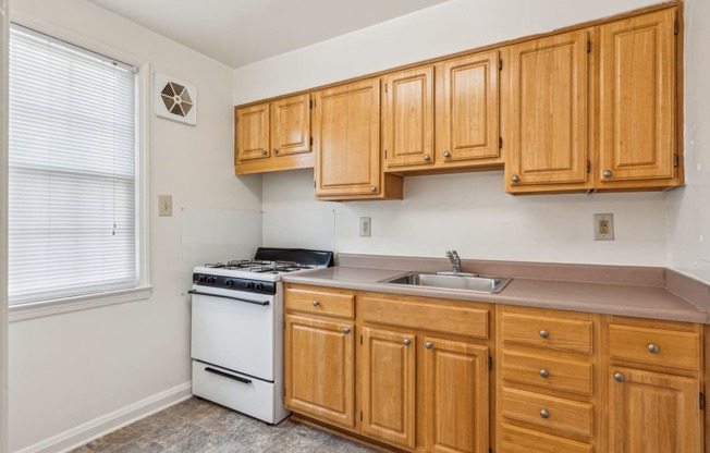 a kitchen with wooden cabinets and a stove and a sink