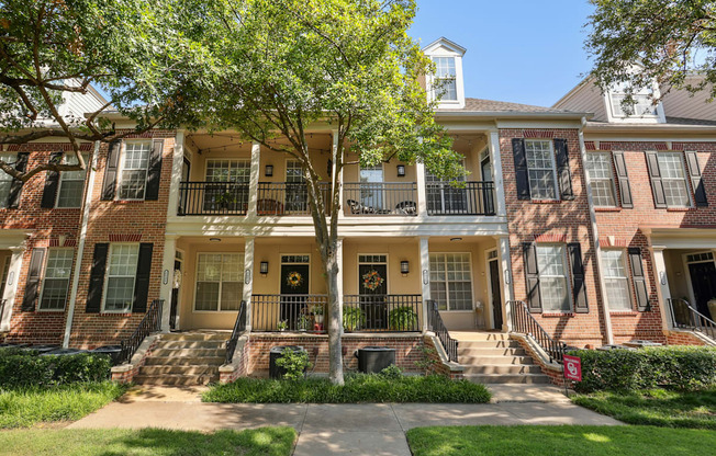 A row of houses with a tree in front.