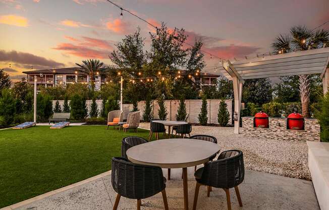 a patio with tables and chairs at sunset