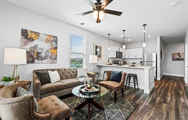 A modern living room with a grey sofa, a coffee table, and a ceiling fan.