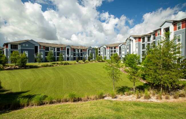 an exterior view of an open field in front of an apartment building