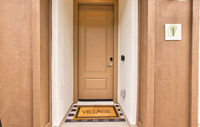 the front door of a building with a door way with a sign that says village