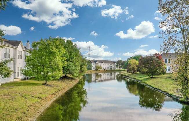 A serene canal with houses on either side under a clear blue sky.