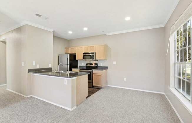 the living room and kitchen of a home with a large window