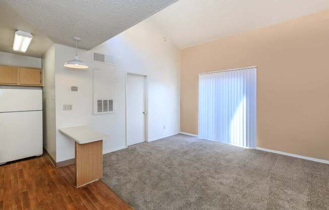 A room with a white ceiling, a white refrigerator, a white cabinet, a white counter, a white door, a white curtain, a white rug, and a white floor.