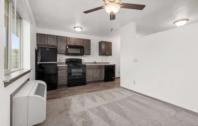 A kitchen with a black fridge, microwave, and oven.