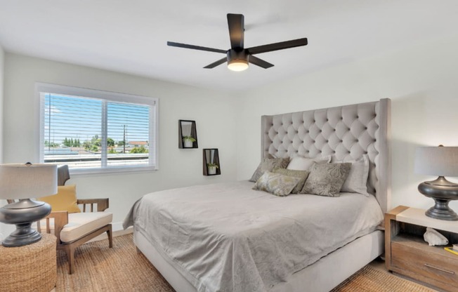 a bedroom with a large bed and a ceiling fan