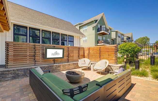 a patio with a couch and chairs in front of a house