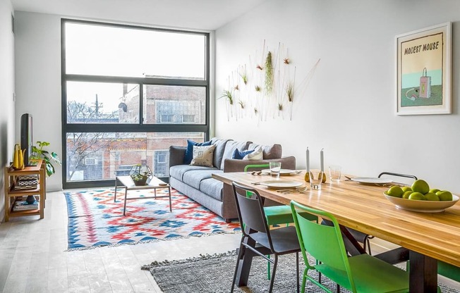 a living room with a large window and a wooden table