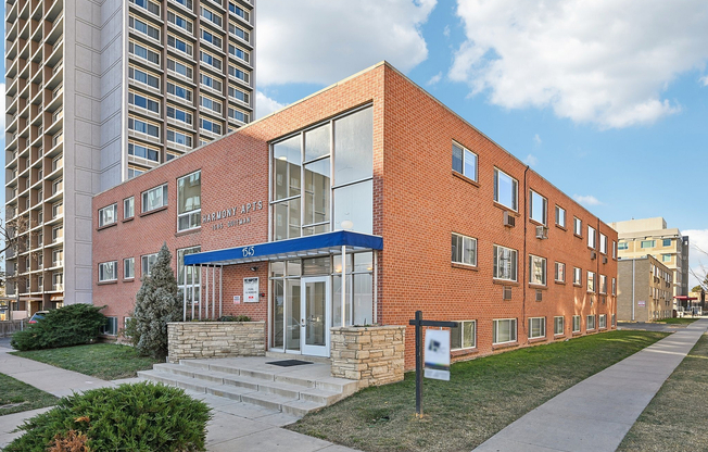 Charming brick apartment building with modern glass entrance, offering urban convenience and a welcoming atmosphere.
