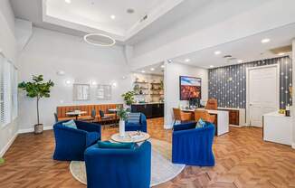 A living room with blue chairs and a white coffee table.