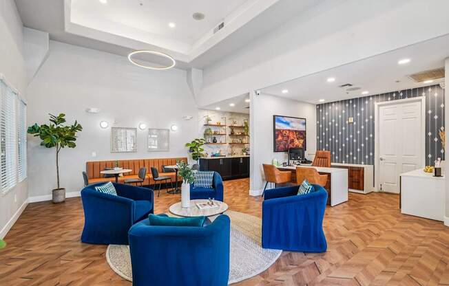 A living room with blue chairs and a white coffee table.