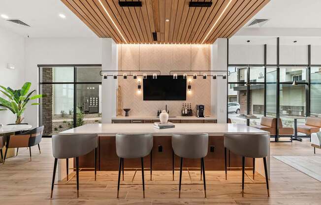 A modern kitchen with a long island and chairs.