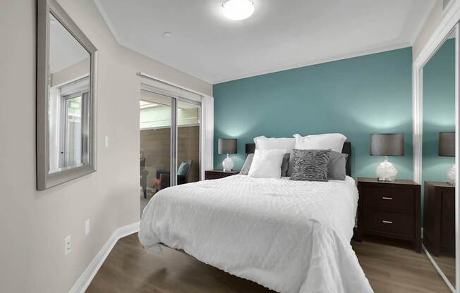 A bedroom with a large bed and a mirror on the wall.