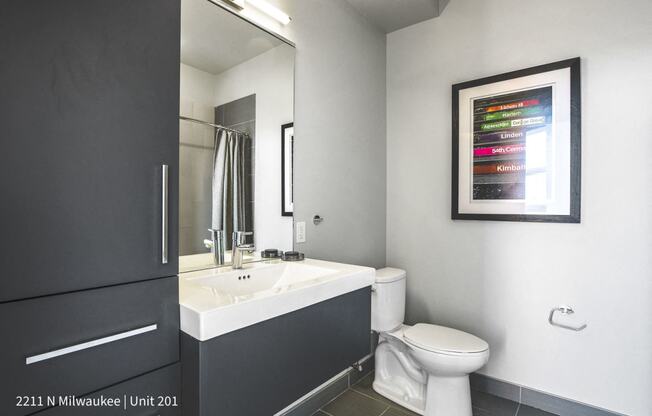 a bathroom with a sink toilet and a mirror