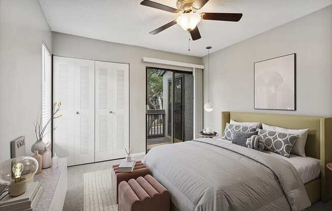 Model Bedroom with Carpet and Patio Accessibility at Huntington Place Apartments located in Sarasota, FL.