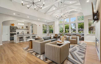A spacious living room with a kitchen area in the background.