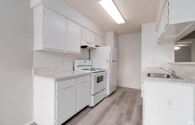 a white kitchen with white appliances and white cabinets