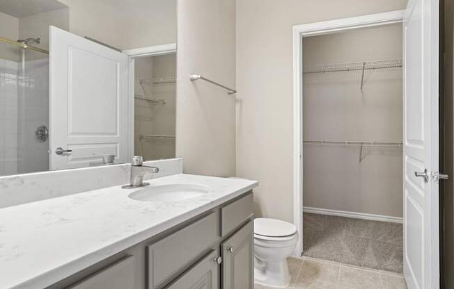 Kenzington bathroom with a white sink and toilet at Encore at Buckingham Apartments in Richardson, TX