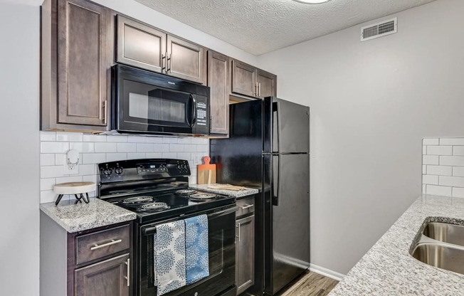our apartments have a modern kitchen with black appliances and granite counter tops