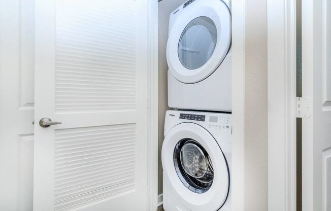 a white washer and dryer in a laundry room with a door