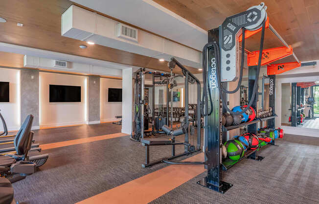 A gym with a variety of equipment including a squat rack and weight bench.