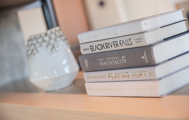 Bookshelf decor with curated white books and vase in lobby