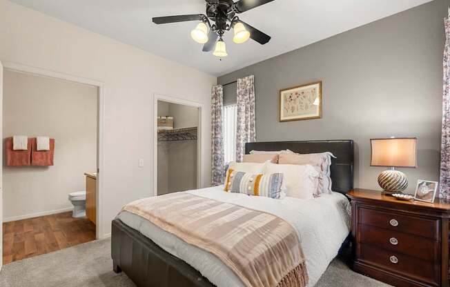 A bedroom with a large bed and a ceiling fan.