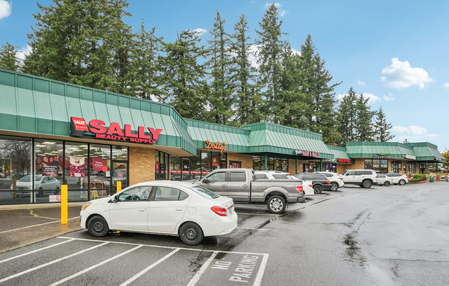 A Sally Beauty store with a white car parked in front.