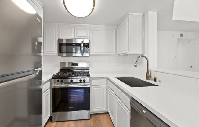 a renovated kitchen with white cabinets and stainless steel appliances