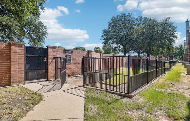 a fenced in area with a fence and a brick building