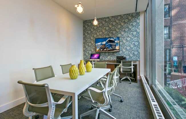 a conference room with a table and chairs and a large window