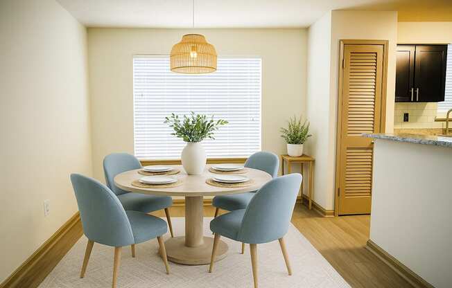 A dining room with a round table and blue chairs.