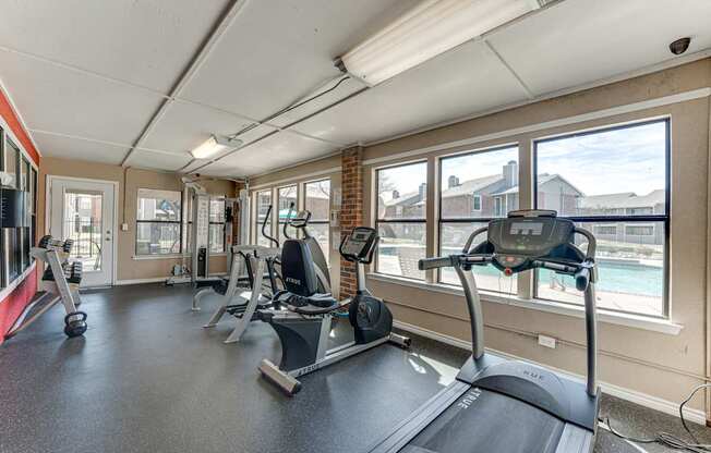 A gym with treadmills, weights, and exercise equipment.