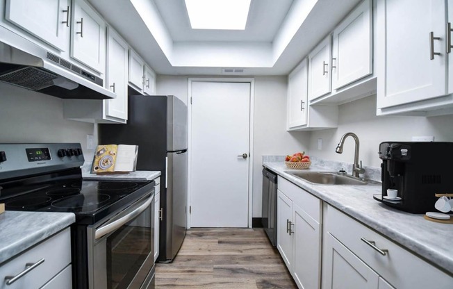a kitchen with white cabinets and black appliances