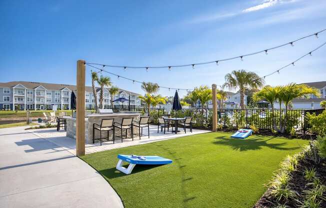 a yard with tables and chairs and a patio with grass