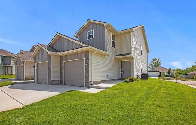 a house with a driveway and a lawn in front of it