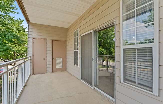 A private patio with a storage closet, window and sliding glass door.