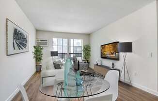 a living room with a glass table and white chairs