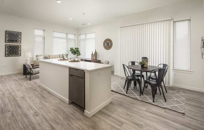 an open kitchen and living room with a dining room table and chairs